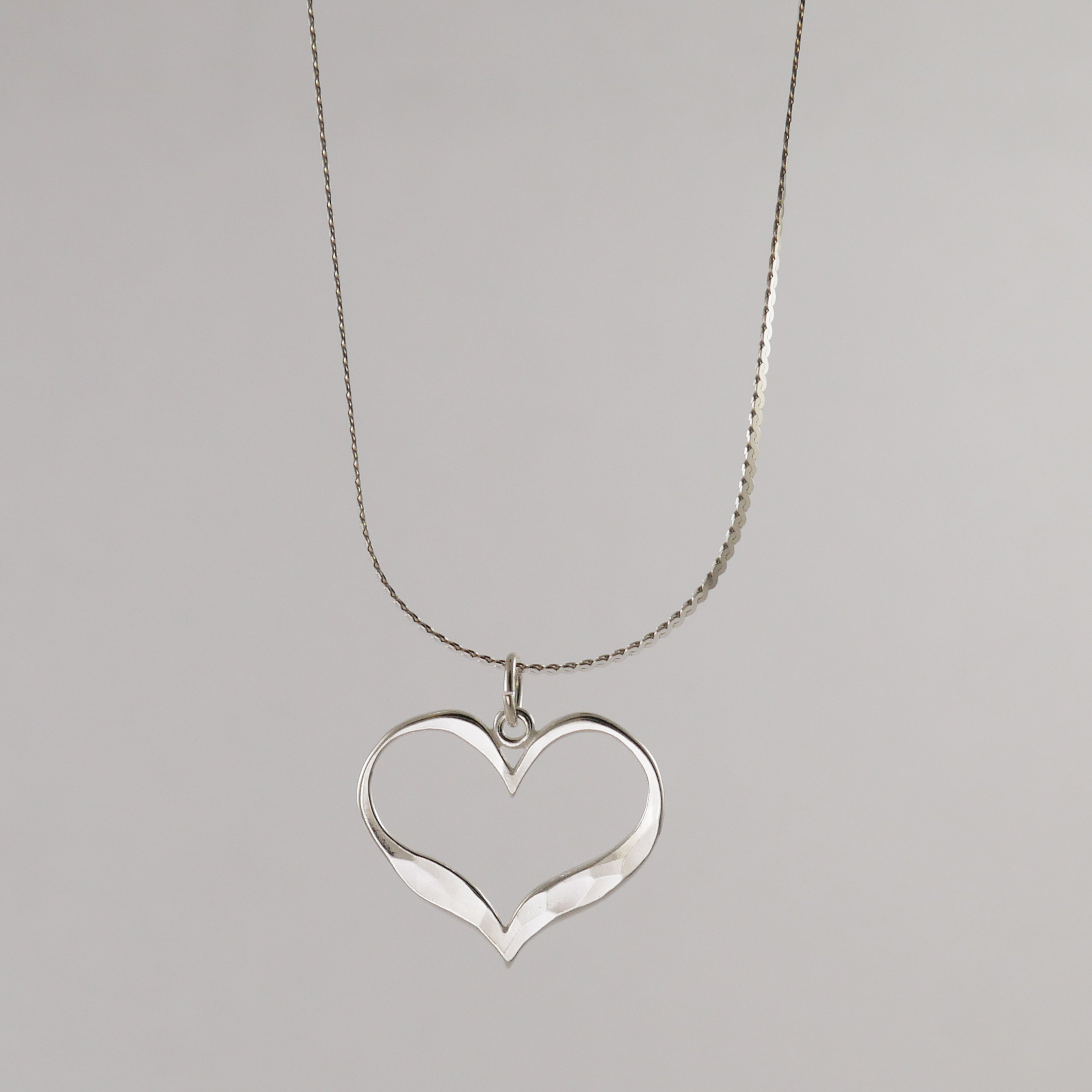 Silver heart-shaped pendant on a chain