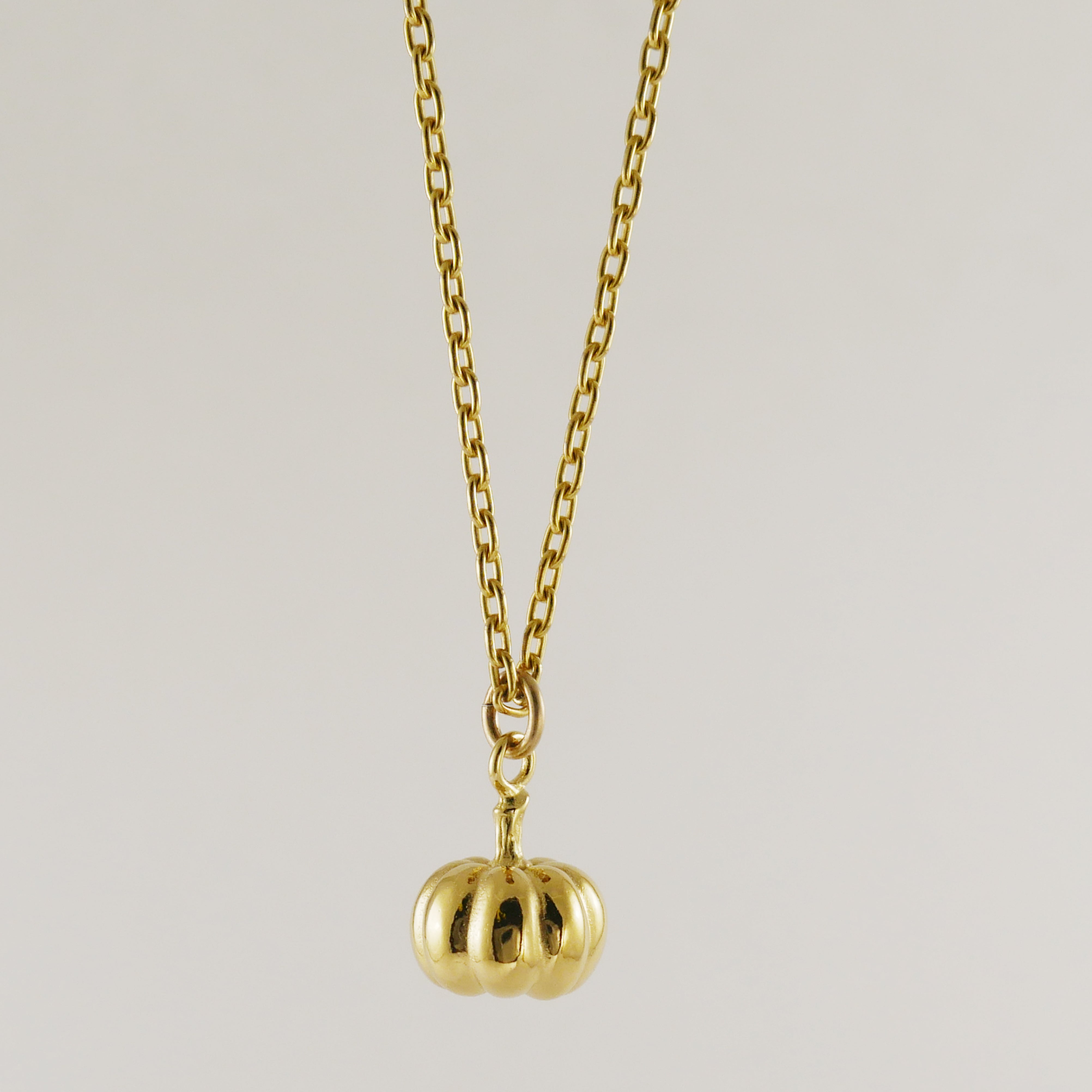 Gold necklace with a small pumpkin pendant
