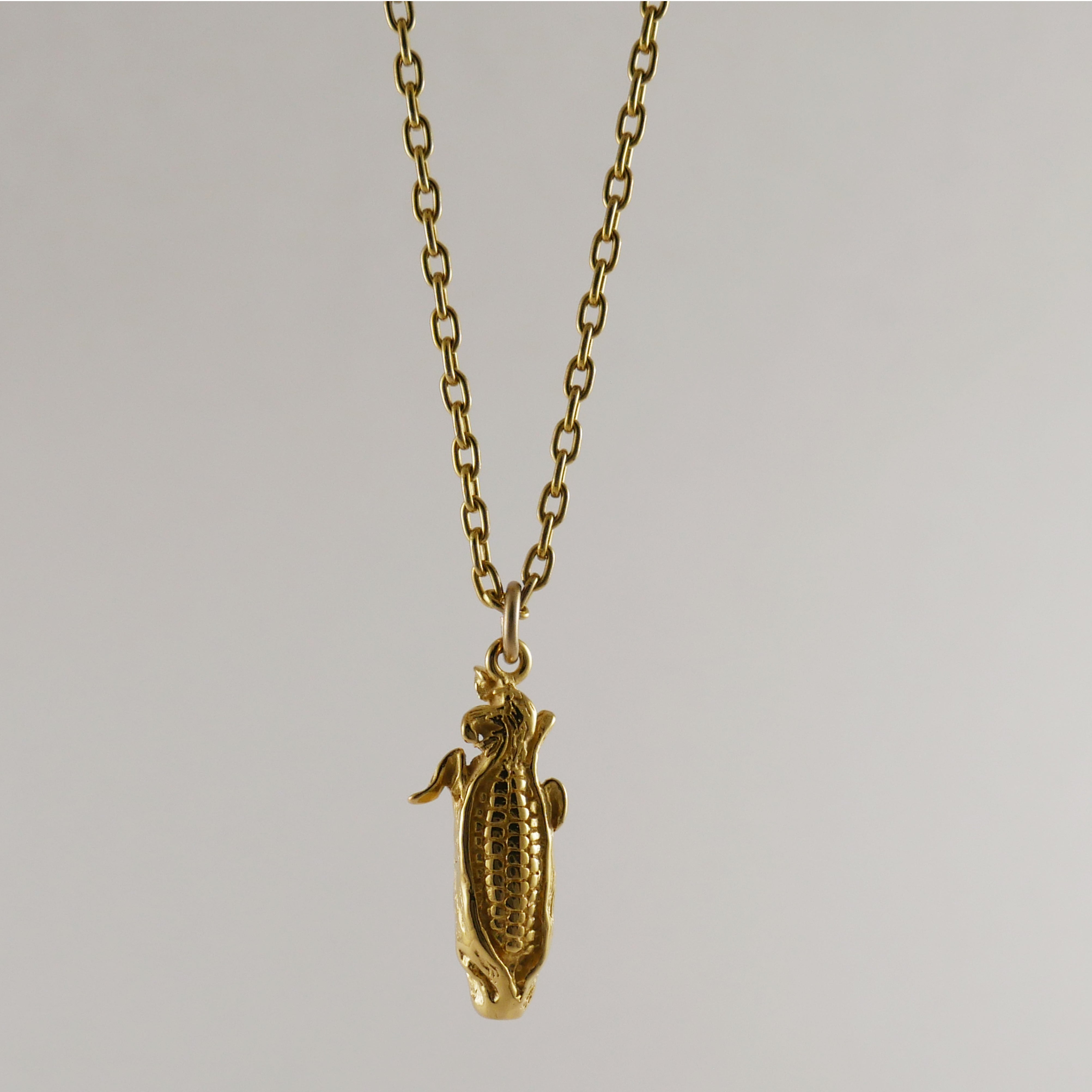 Gold necklace with a corncob pendant on necklace
